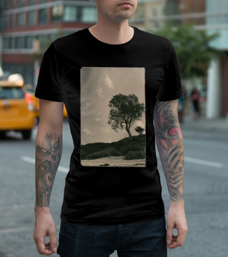 Tree on Grassy Hillside Under Cloudy Sky T-Shirt
