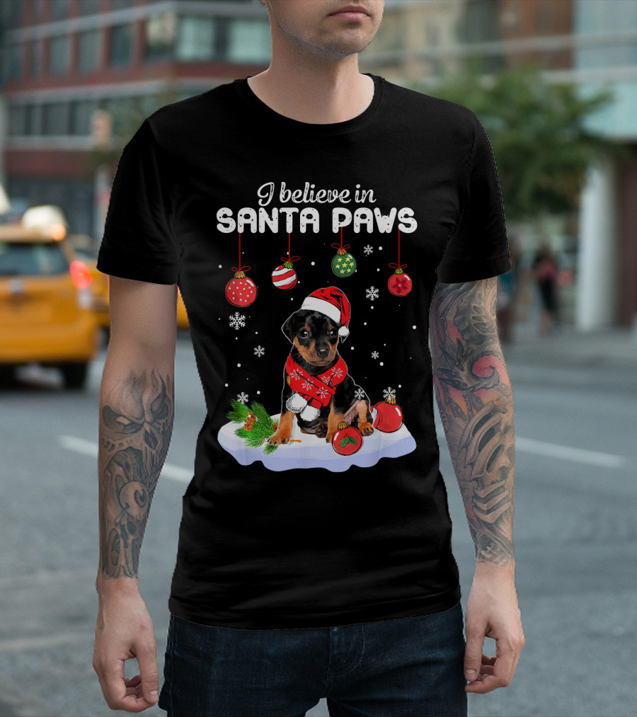 I Believe in Santa Paws Miniature Pinscher Christmas Puppy in Red Hat and Scarf with Hanging Ornaments and Snowflakes T-Shirt