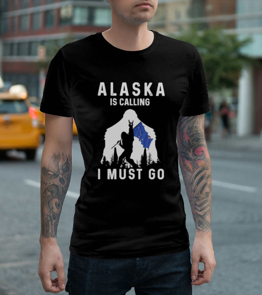 Alaska Is Calling I Must Go Bigfoot Holding Alaska Flag T-Shirt