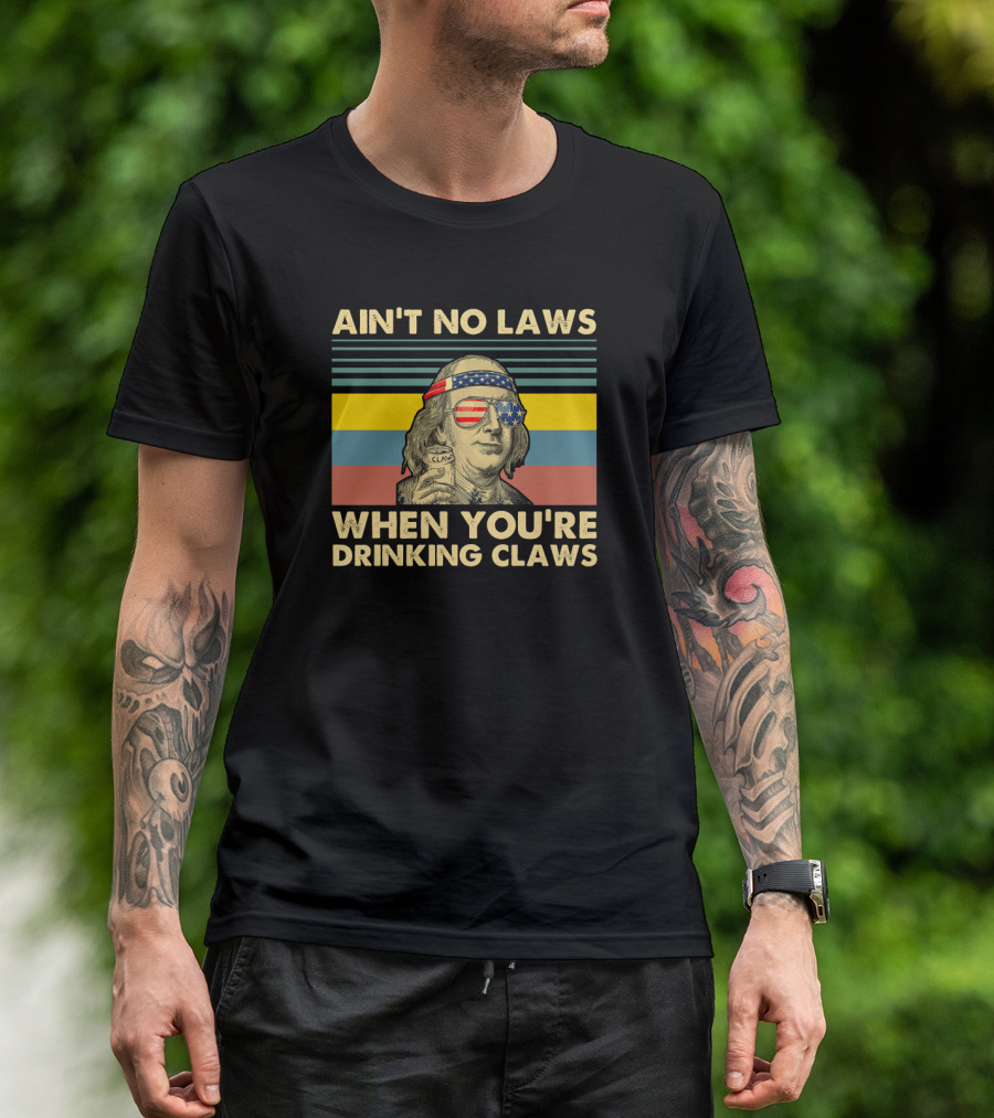 AIN'T NO LAWS WHEN YOU'RE DRINKING CLAWS VINTAGE BENJAMIN FRANKLIN WITH AMERICAN FLAG GLASSES AND HEADBAND CAN OF CLARIFIED BEVERAGE STRIPES BACKGROUND T-Shirt