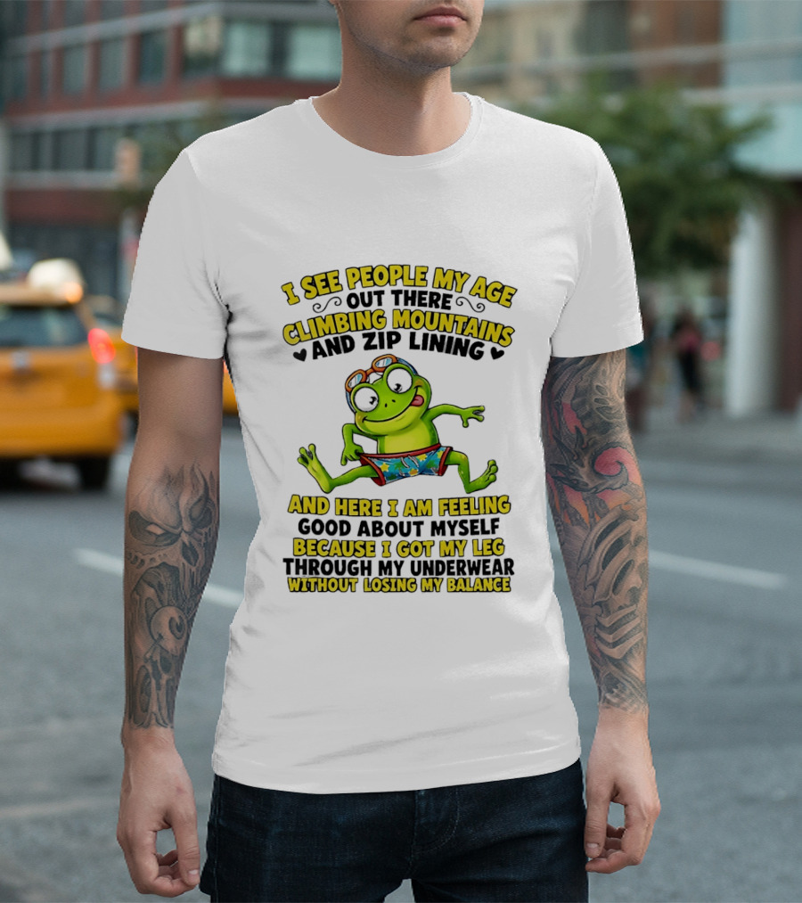 I See People My Age Climbing Mountains And Zip Lining Cartoon Frog Feeling Good Without Losing Balance T-Shirt