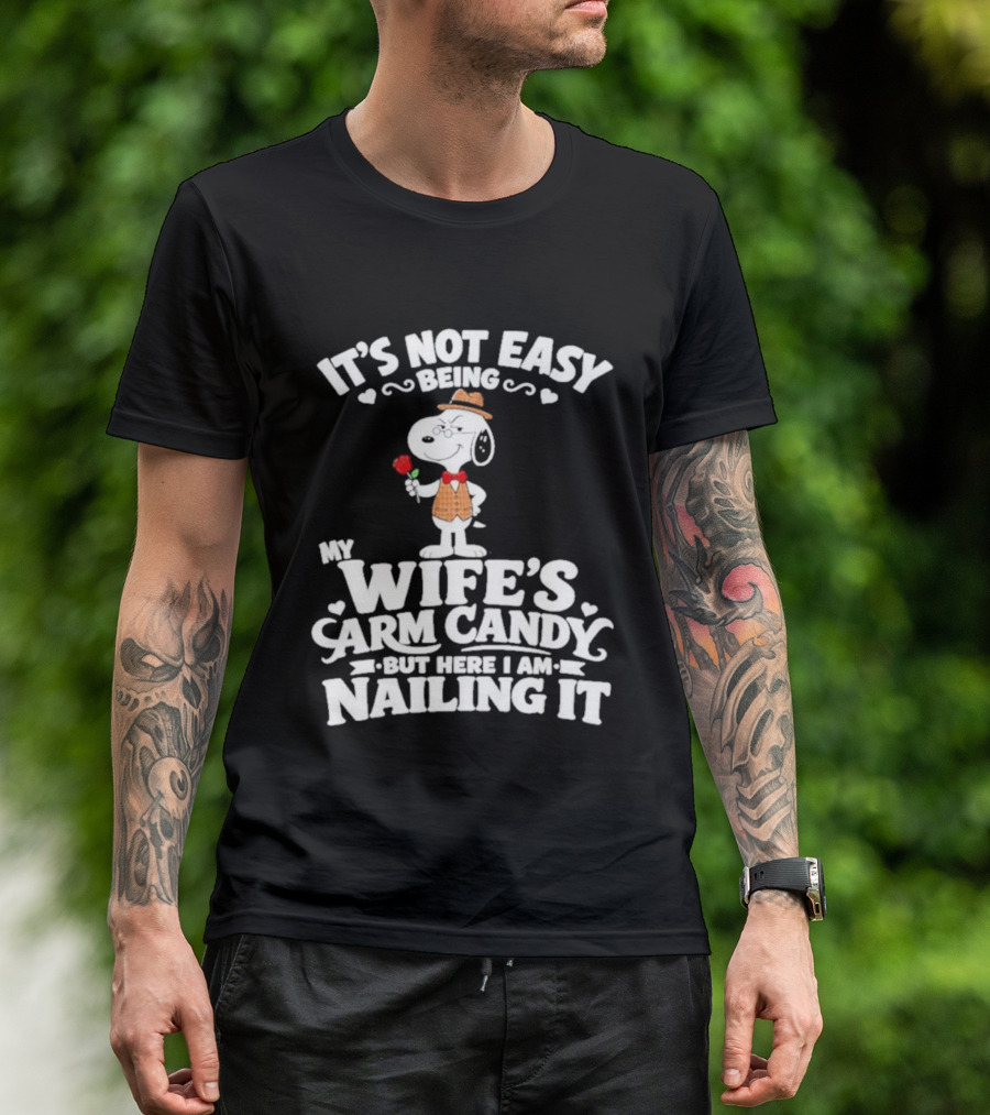 Snoopy It's Not Easy Being My Wife's Arm Candy But Here I Am Nailing It T-Shirt