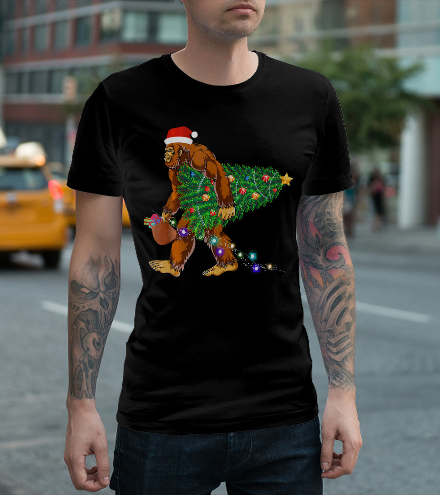 Santa Hat Bigfoot Holding Christmas Tree with Lights and Gifts T-Shirt